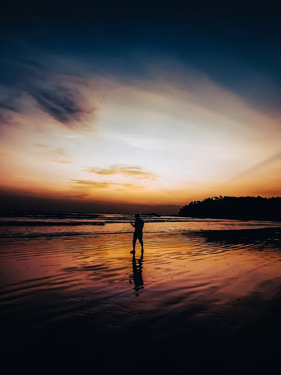 Silhouette on a mirror flat beach at sunset